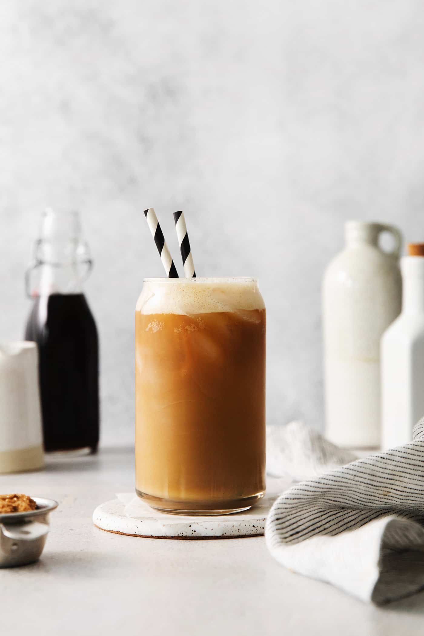 A copycat Starbucks oatmilk shaken espresso in a glass with two straws