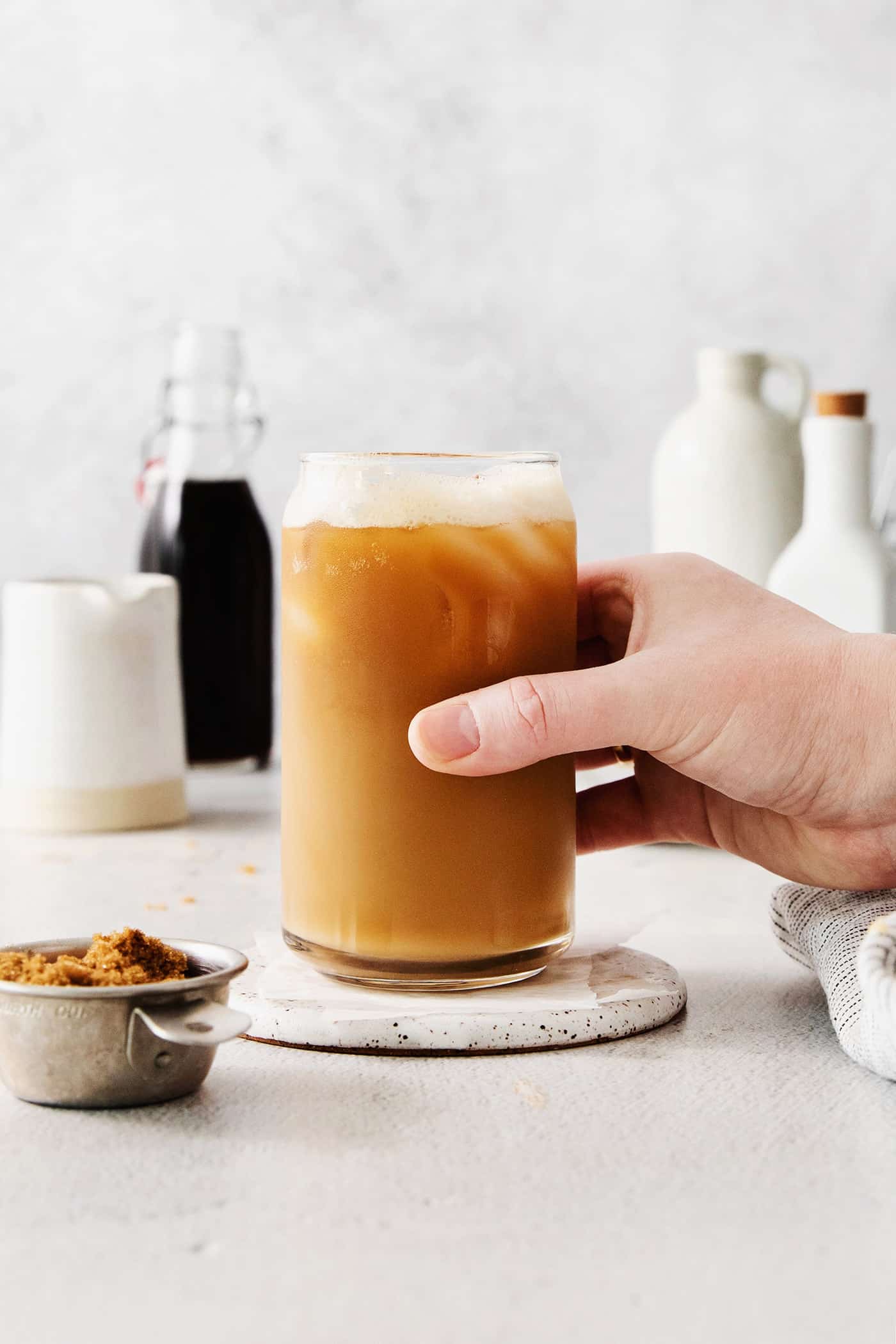 A hand grabbing an iced brown sugar oatmilk shaken espresso