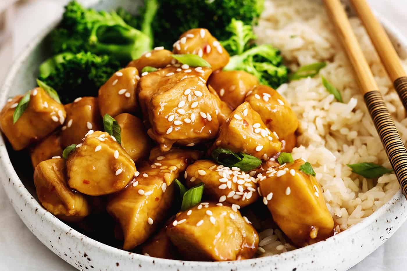 Mandarin chicken on a plate with broccoli and rice