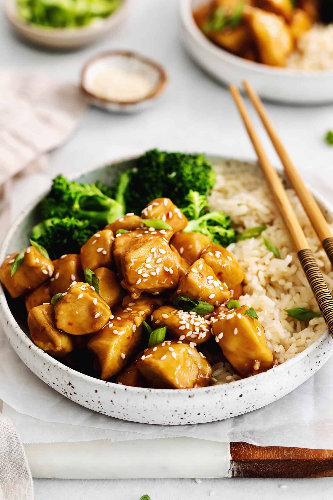 A plate of mandarin chicken with rice and broccoli