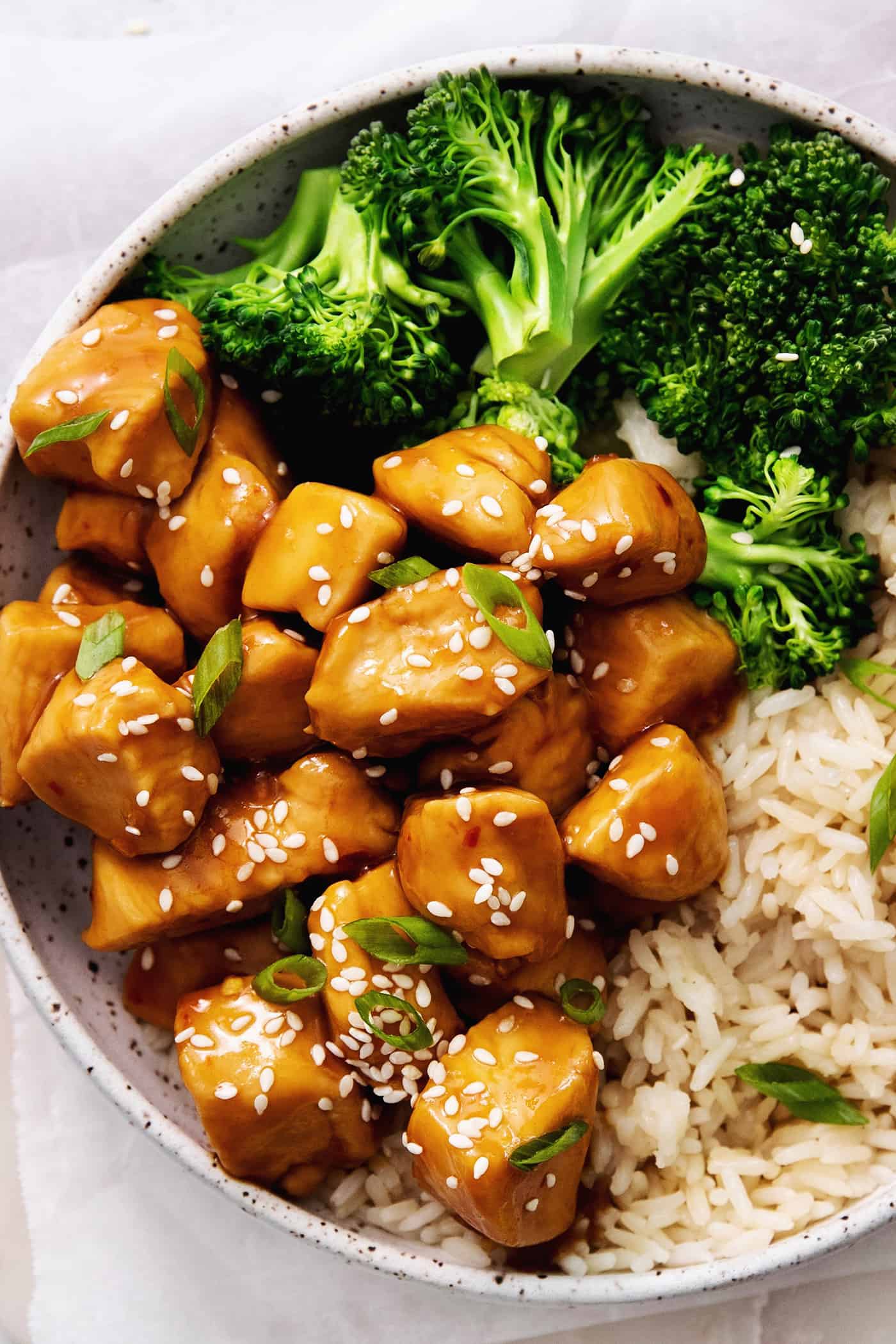 A plate of mandarin orange chicken with rice and broccoli