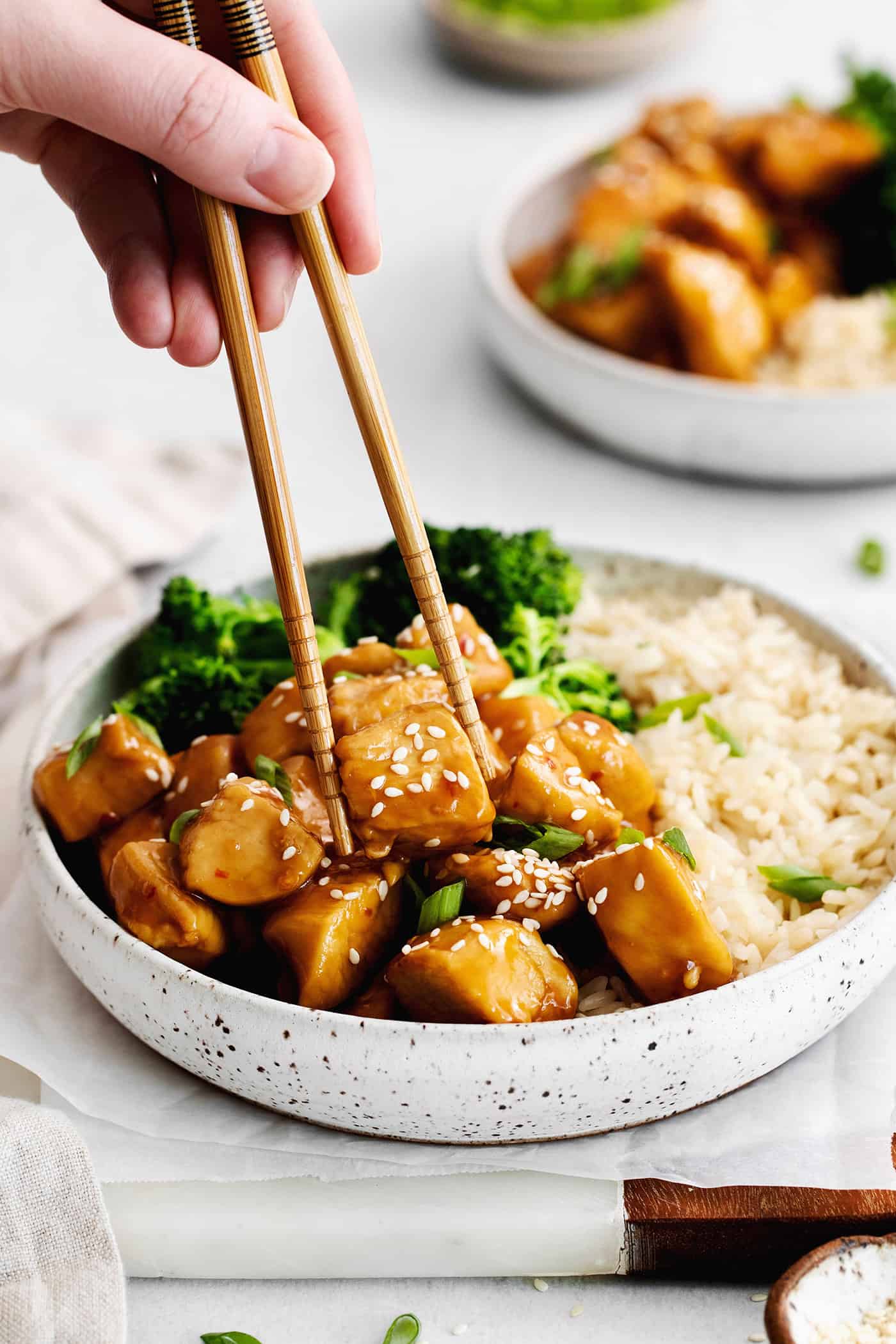 Chopsticks grabbing a piece of mandarin chicken