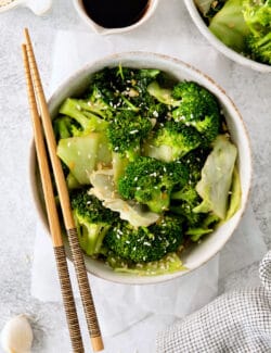 Overhead view of a bowl of Panda express super greens with chopsticks laying across the bowl