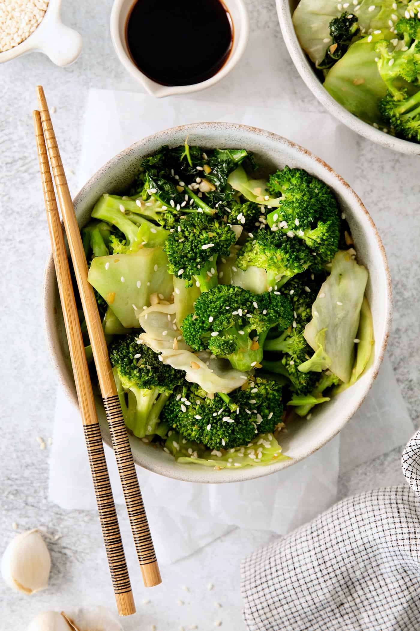 Overhead view of a bowl of Panda express super greens with chopsticks laying across the bowl