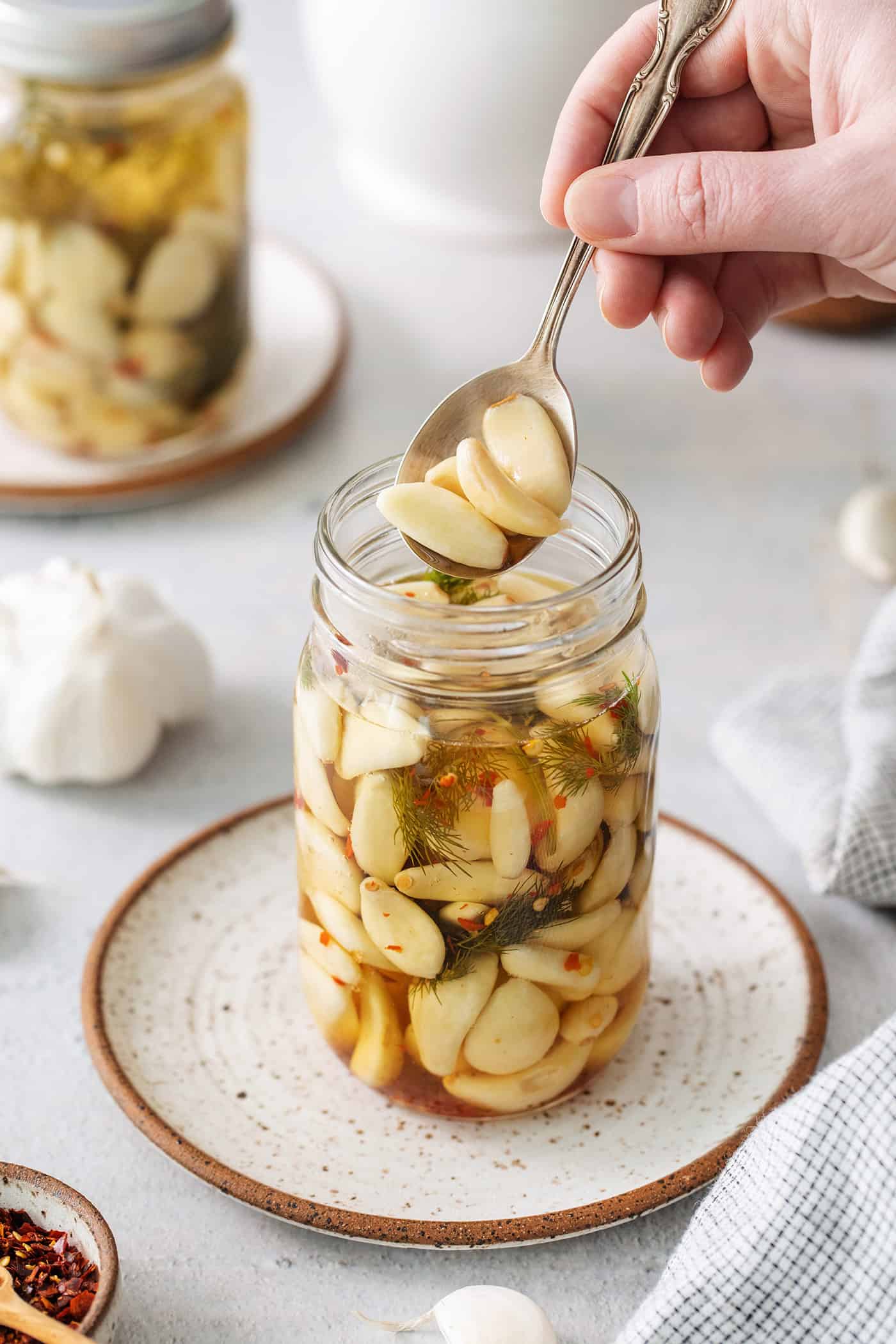 A spoon of garlic above a jar