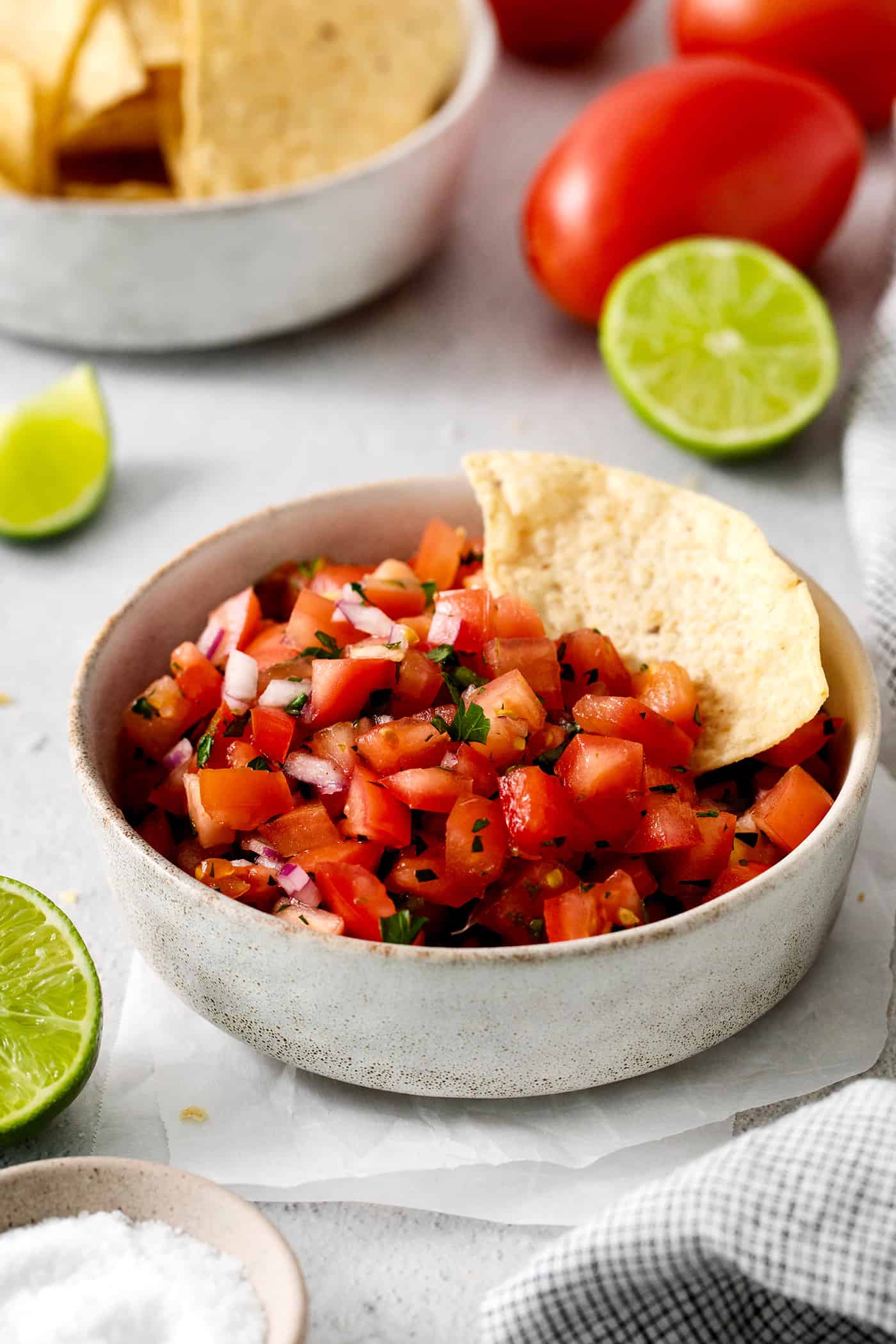 A tortilla chip in a bowl of pico de gallo