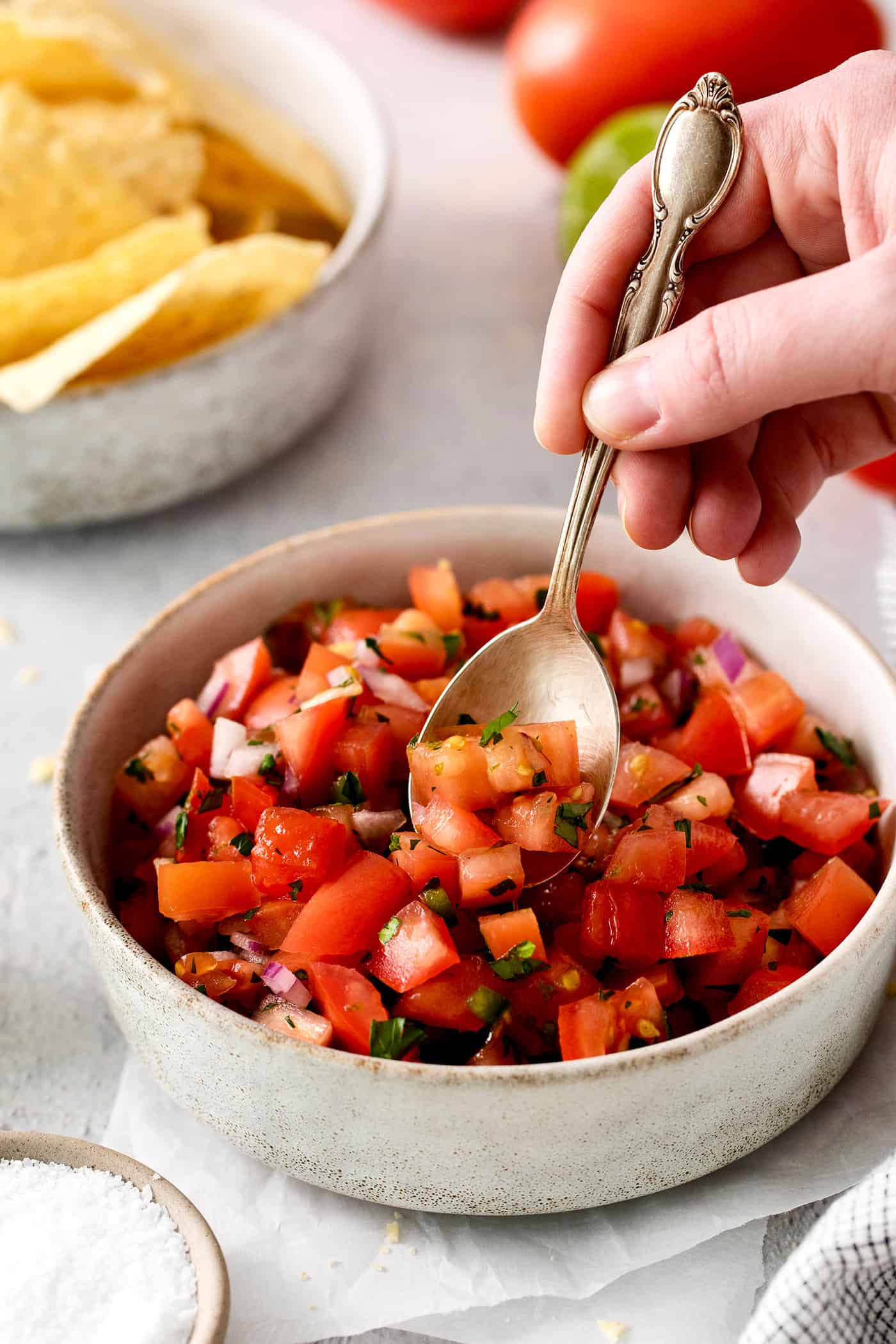 A spoon in a bowl of pico de gallo