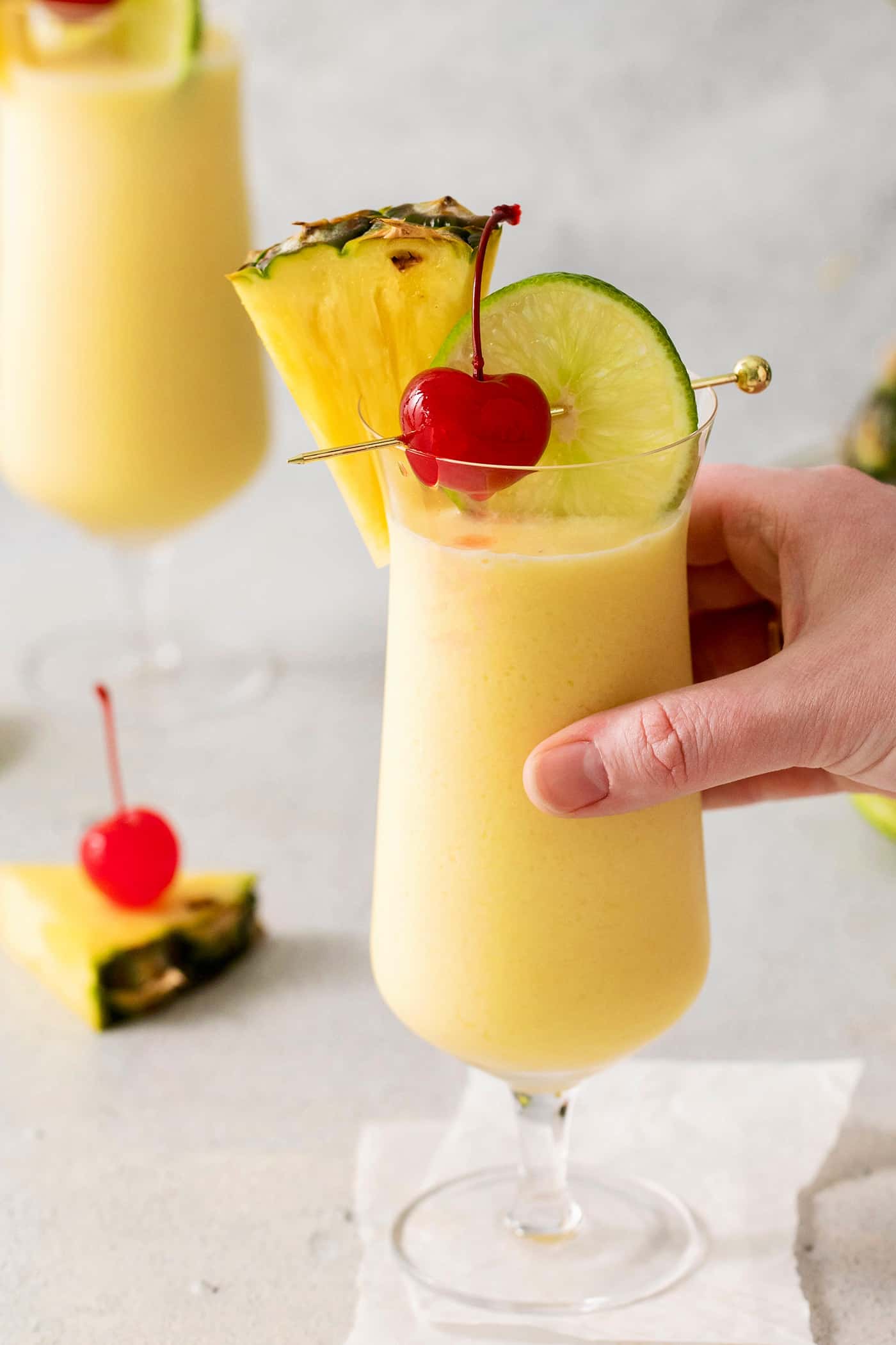 A hand grabbing a pina colada drink