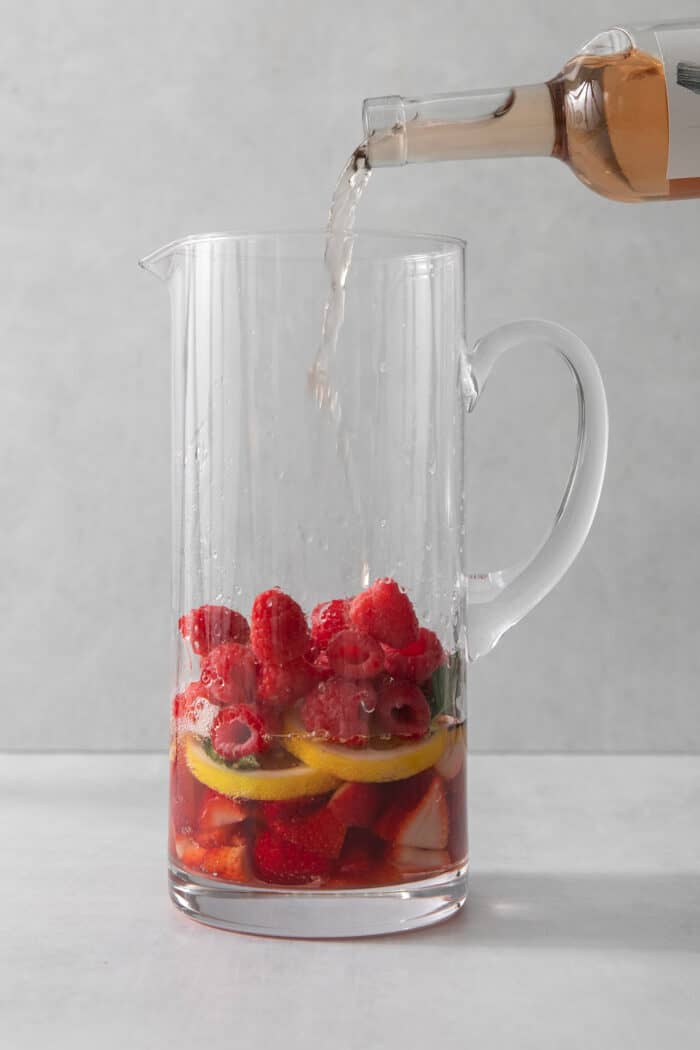 Wine is poured in a pitcher of sangria.
