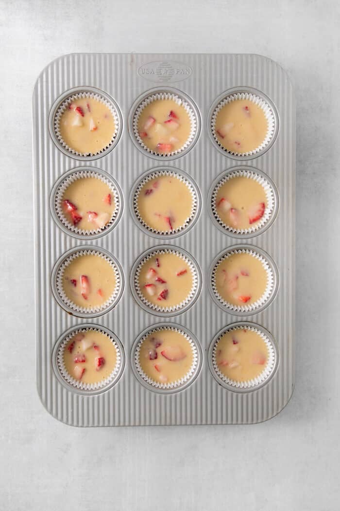 Strawberry cupcake batter is shown in a cupcake tin.