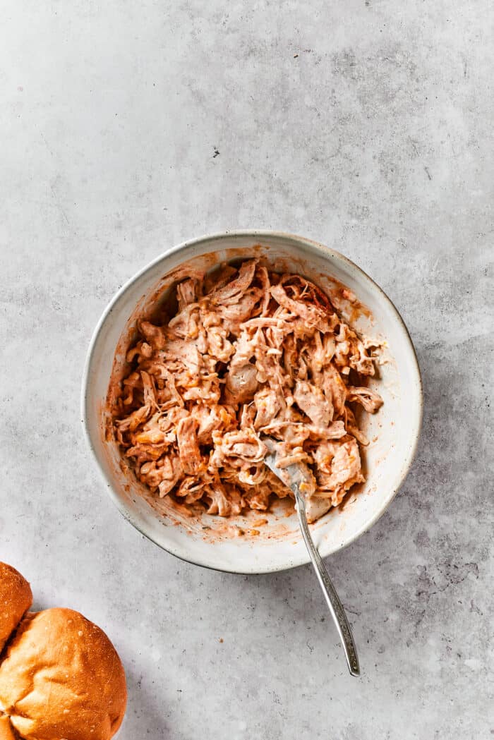 Mixing ranch into shredded chicken.