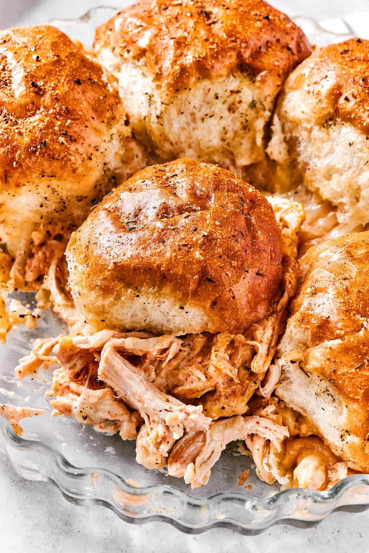 Buffalo chicken sliders are shown in a metal dish.