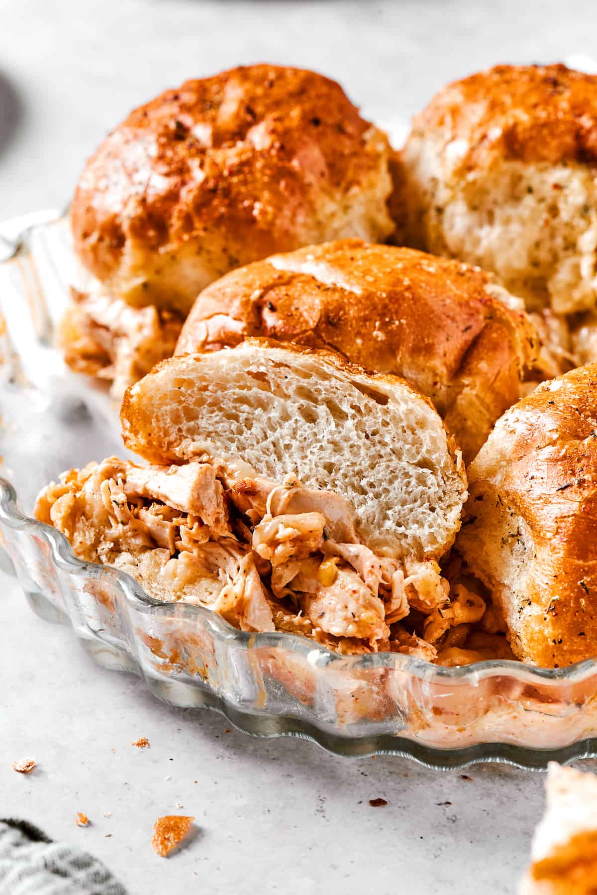 Buffalo chicken sliders are shown in a metal dish.