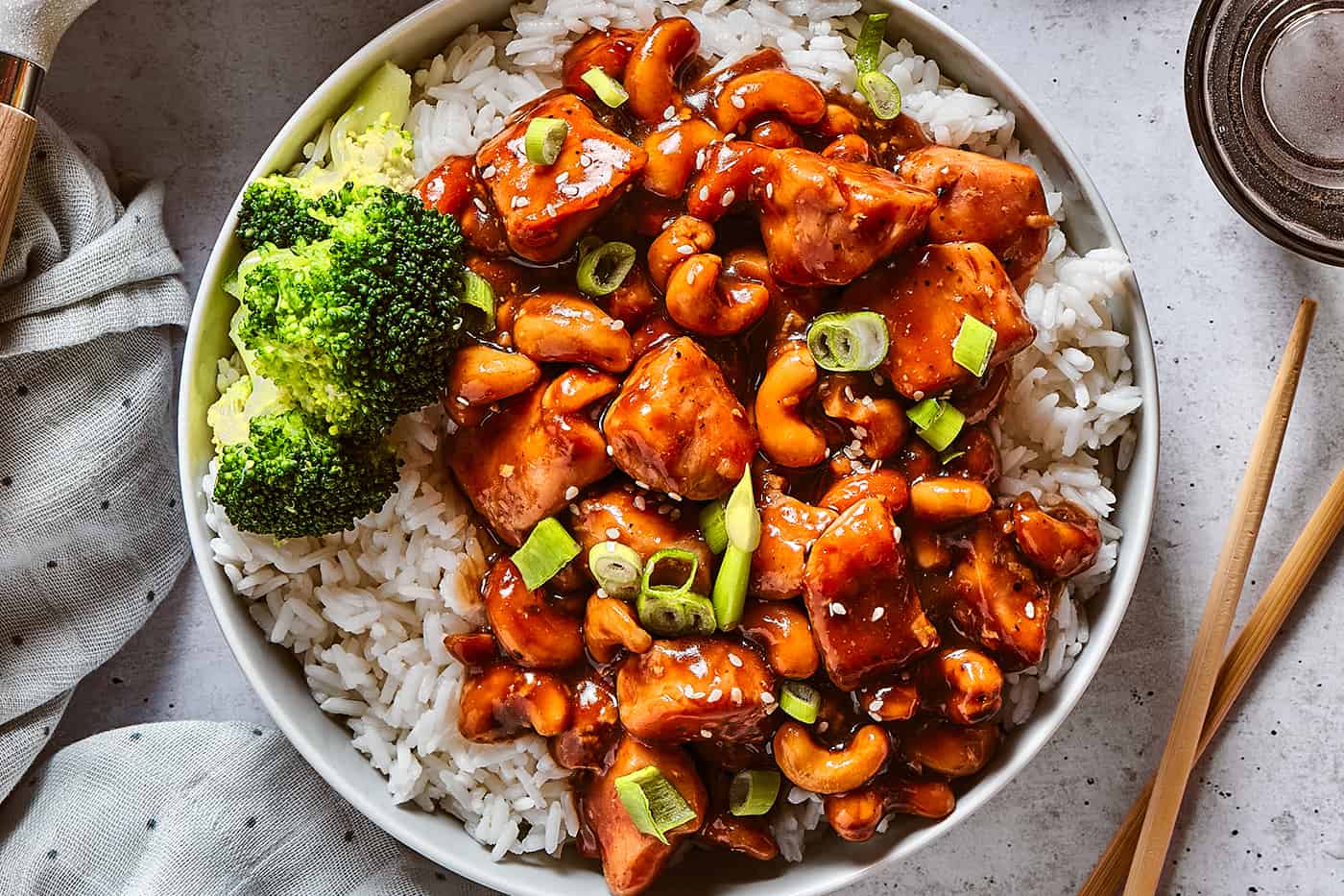 overhead photo of Chinese cashew chicken with rice and broccoli in a white bowl
