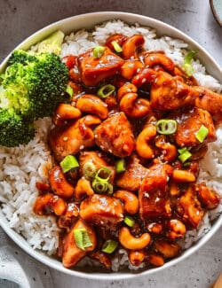 Chinese cashew chicken with rice and broccoli in a white bowl