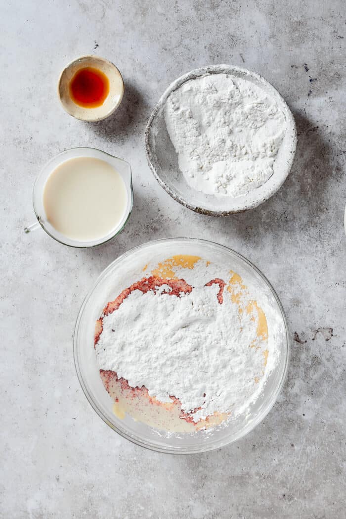 Mixing the flour with the wet mixture in bowls.