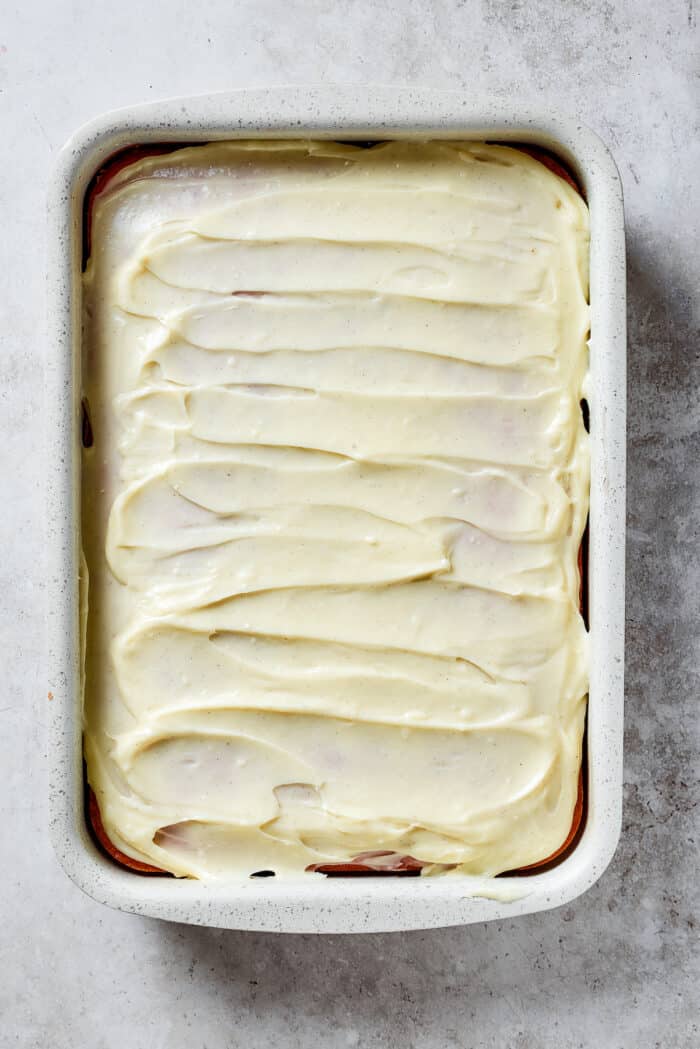 Strawberry crunch cake is topped with cream cheese filling.