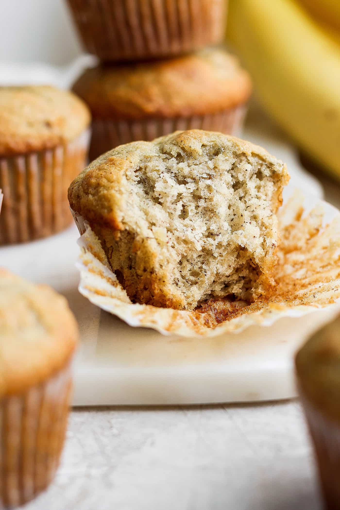 a banana muffin with a couple bites taken out