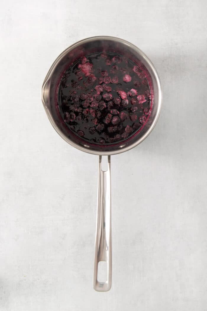 Boiling blueberries and sugar in a saucepan