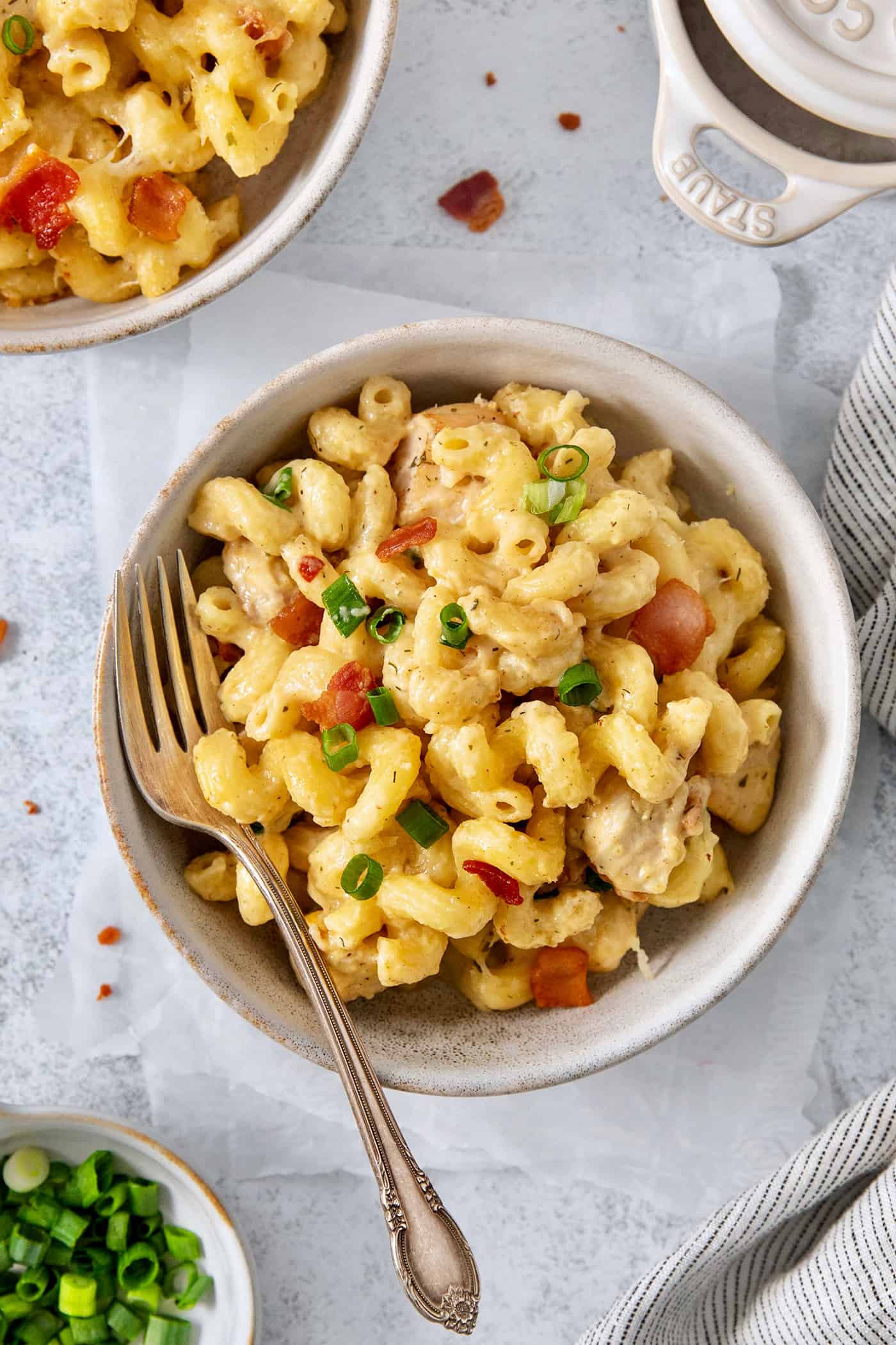 A bowl of chicken bacon ranch pasta on a white background with a fork.