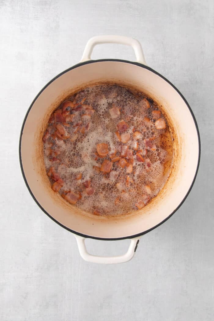 Bacon cooks in a pot.