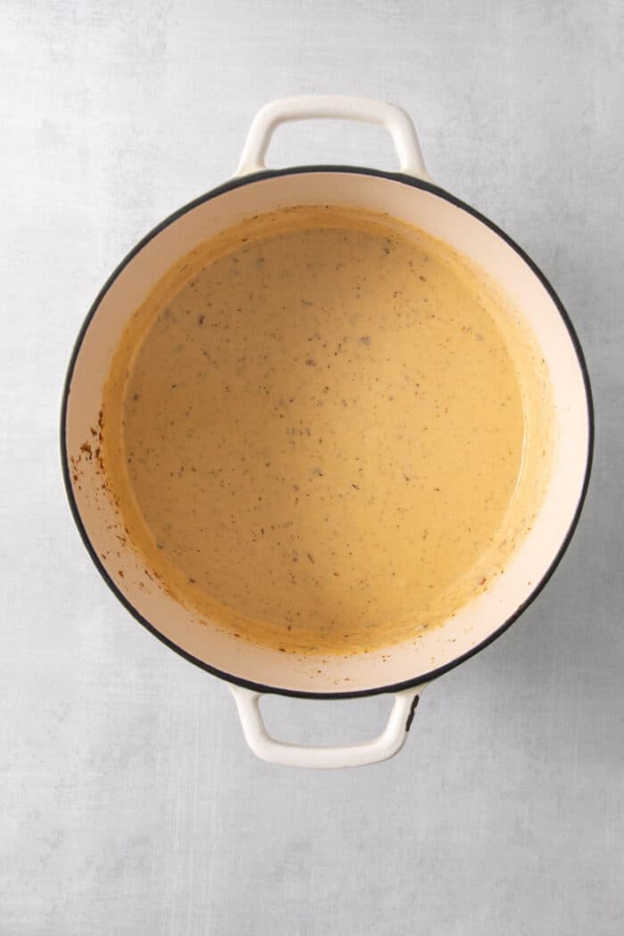 An overhead photo shows cheese sauce in a pot.