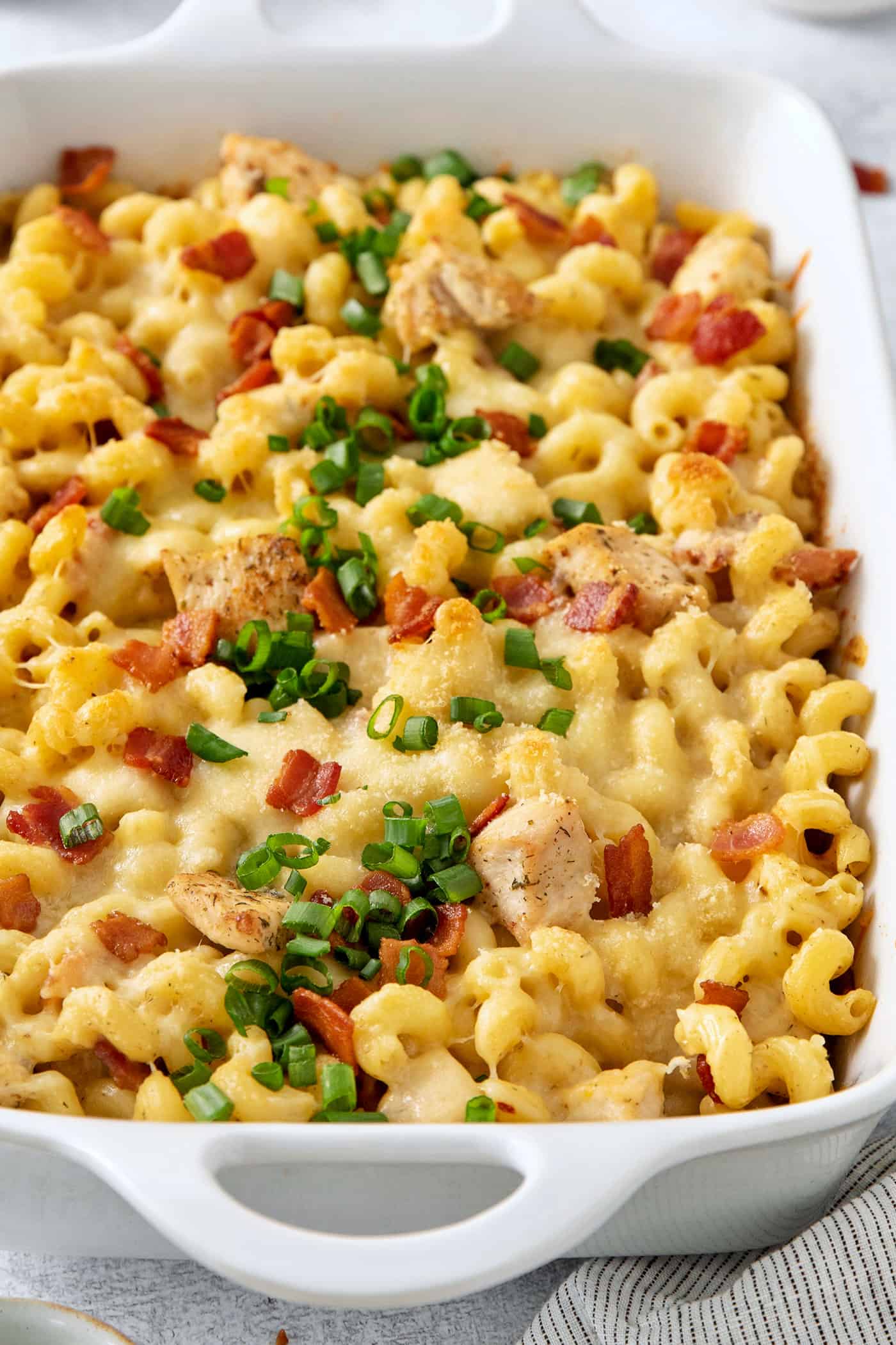 A close up shot shows chicken ranch pasta covered with sliced green onions.