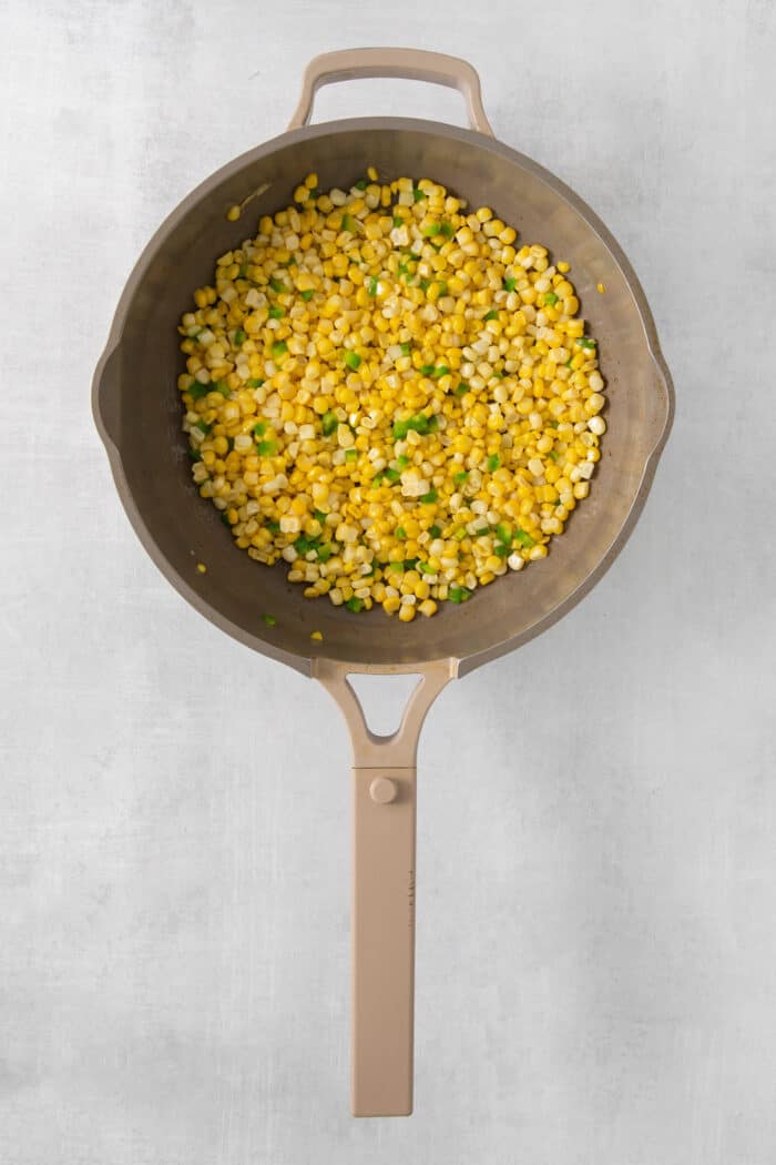 Corn and diced jalapenos in a skillet