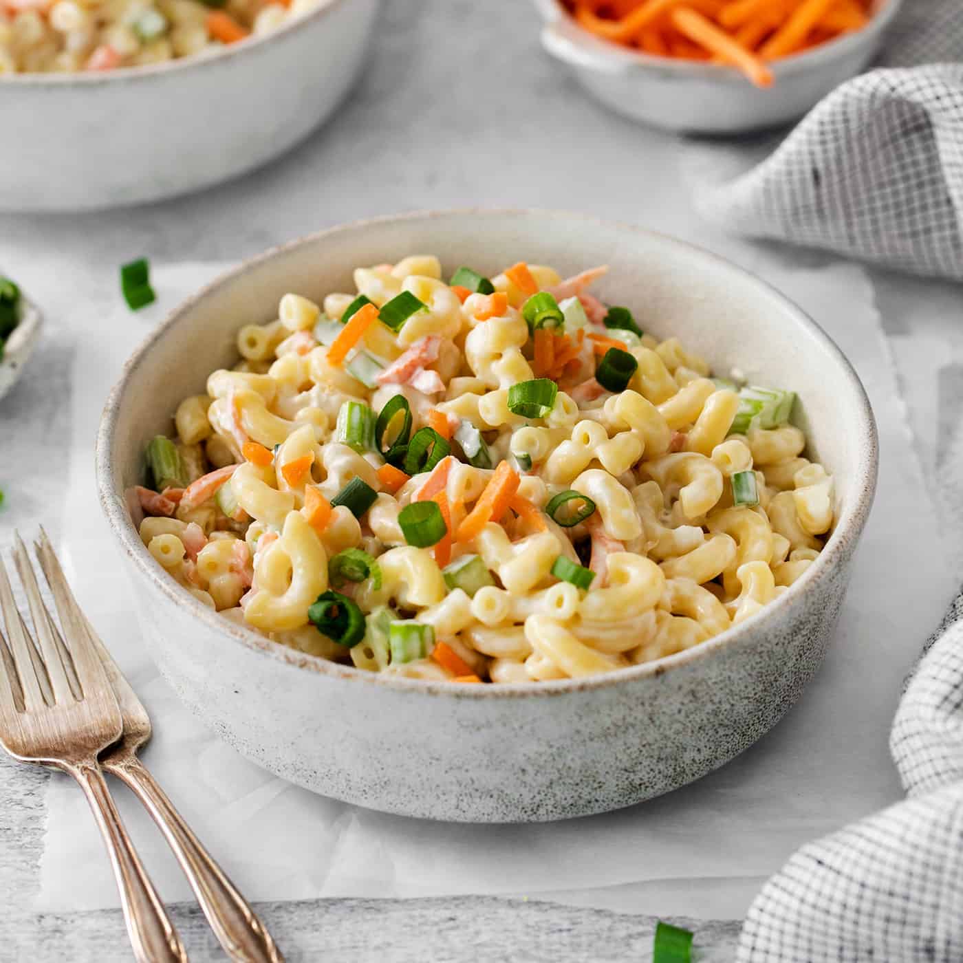 A white bowl of hawaiian macaroni salad on a table.