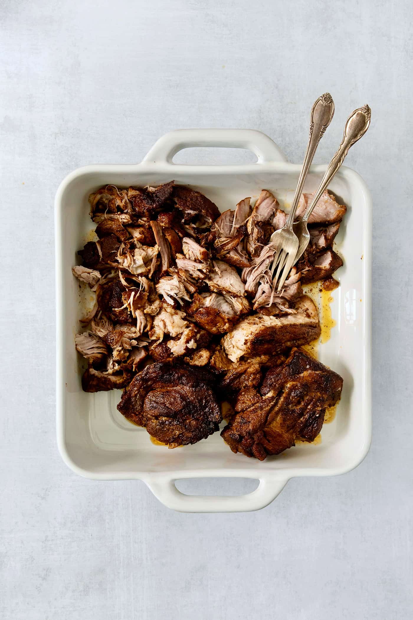 Shredding cooked pork with two forks.
