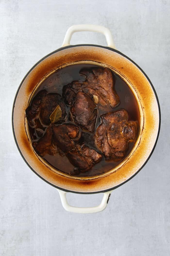 Pork cooks in a Dutch oven.