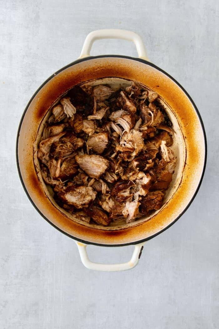 Cooked pork is shown in a Dutch Oven.
