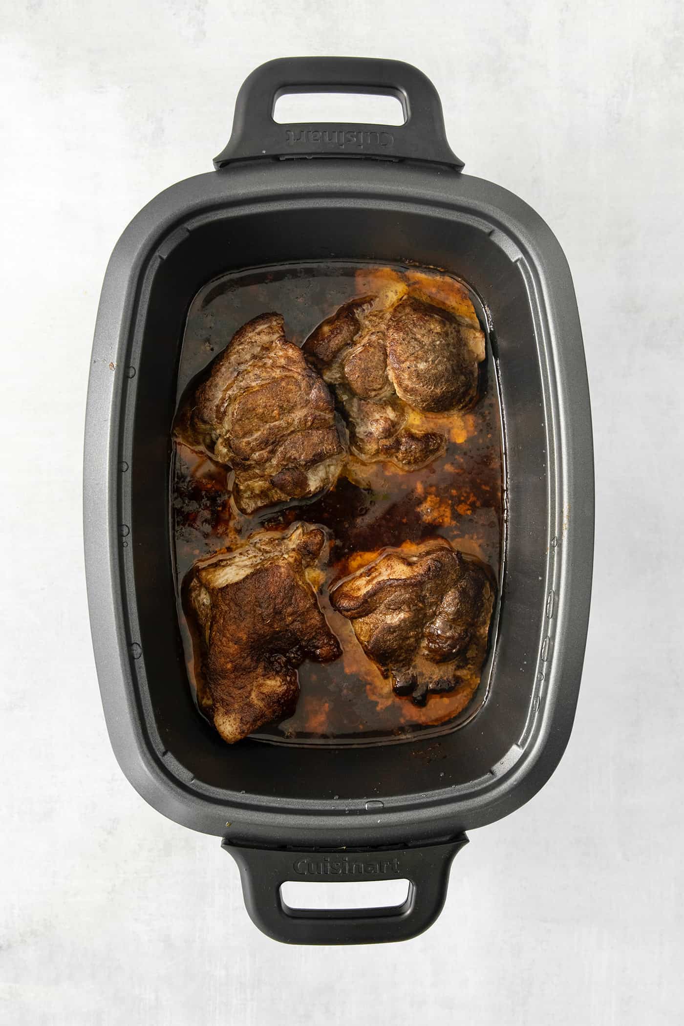 Pork cooks in a slow cooker.