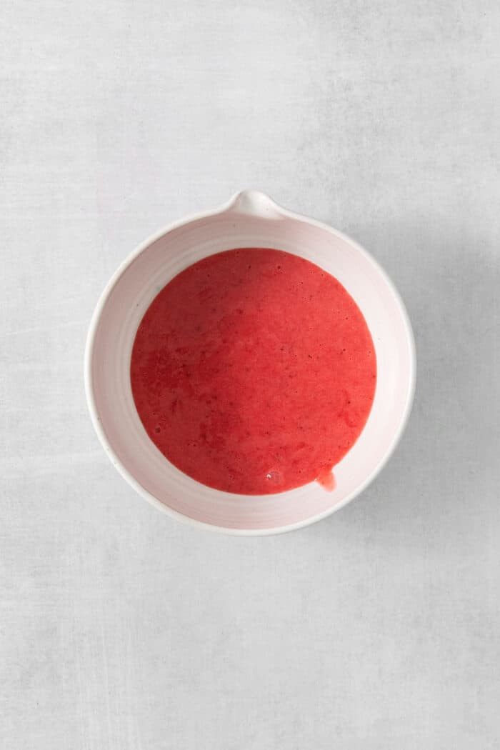 A white bowl of strawberry puree.