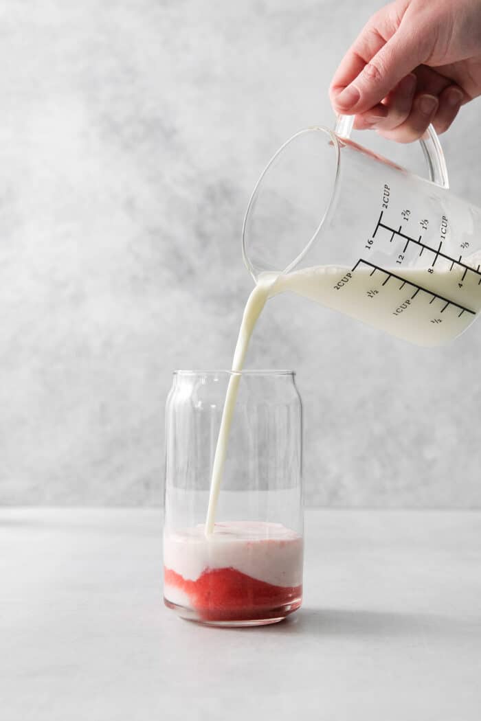 Pouring milk into strawberry puree.