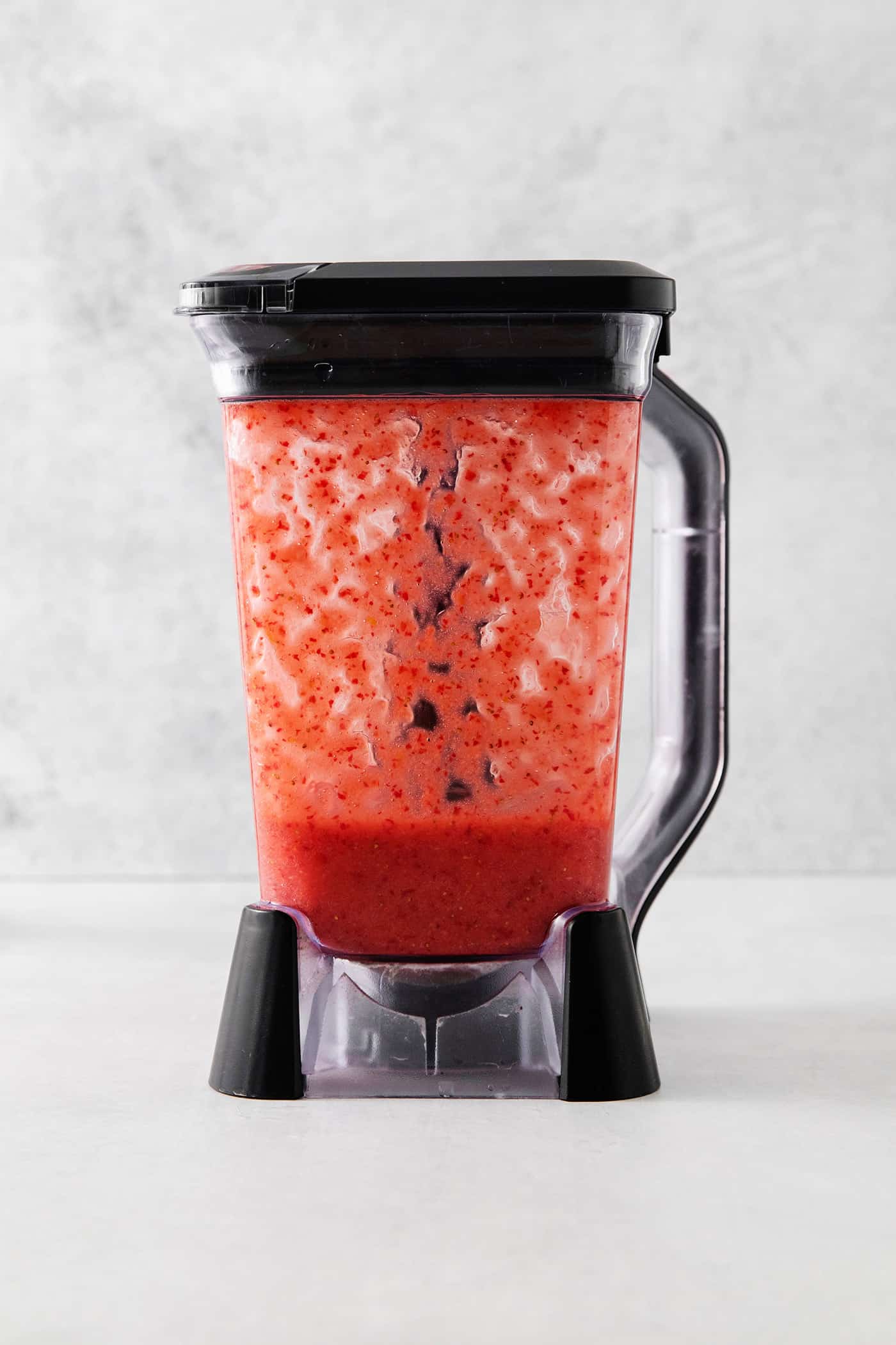 a blender carafe with strawberries blended in it
