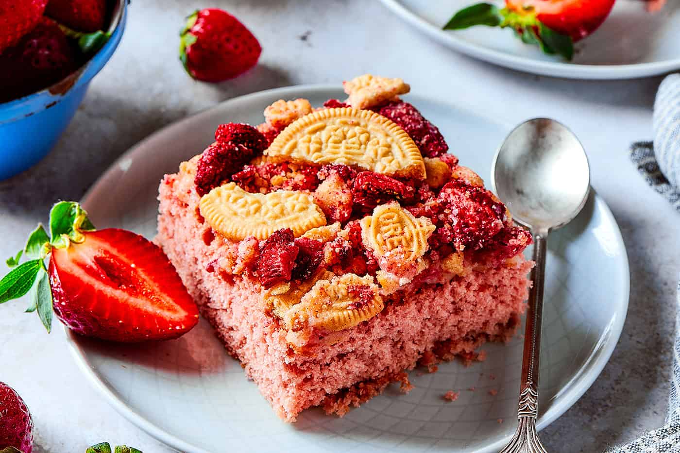 a piece of strawberry cake with a crunchy topping, plus fresh strawberries