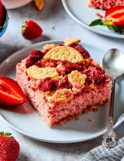 a piece of strawberry cake with a crunchy topping, plus fresh strawberries