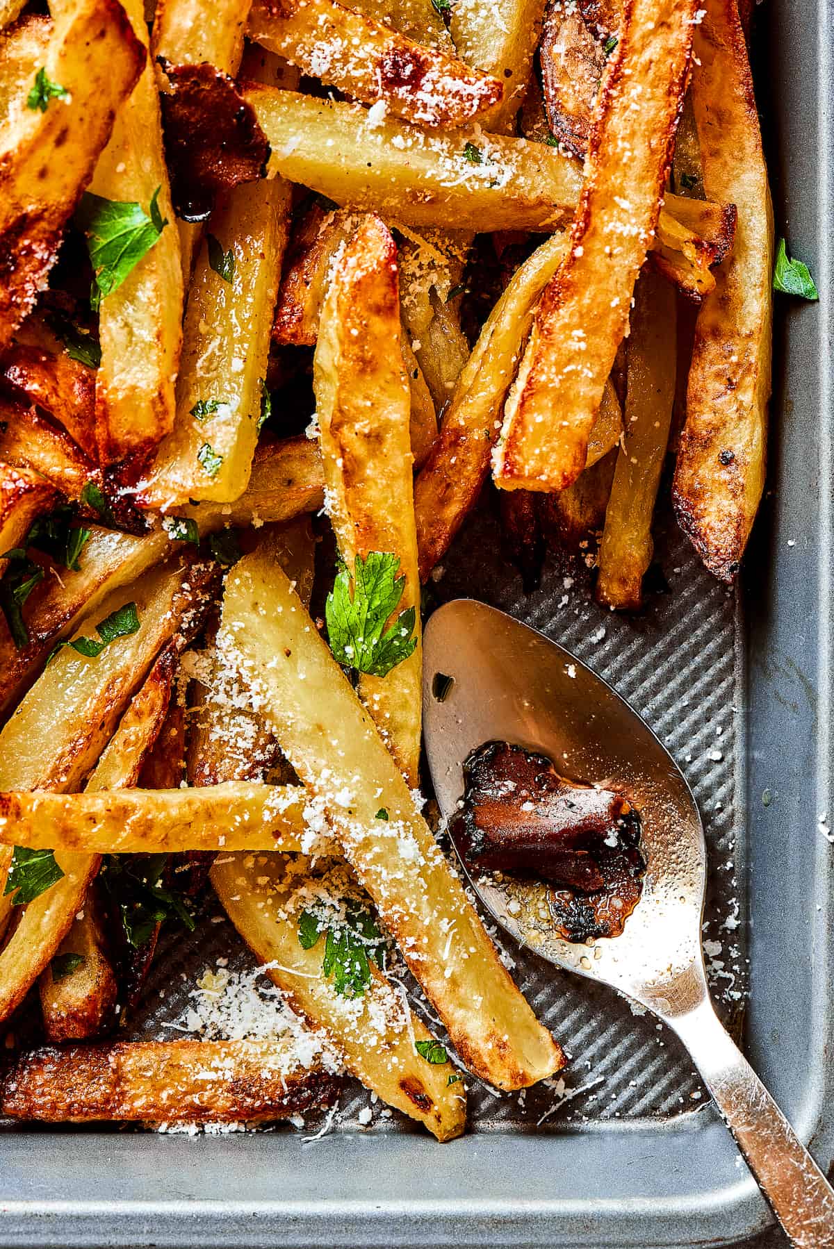 A tray of truffle fries with a spoon.