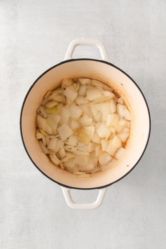 cooking onions in a white pot