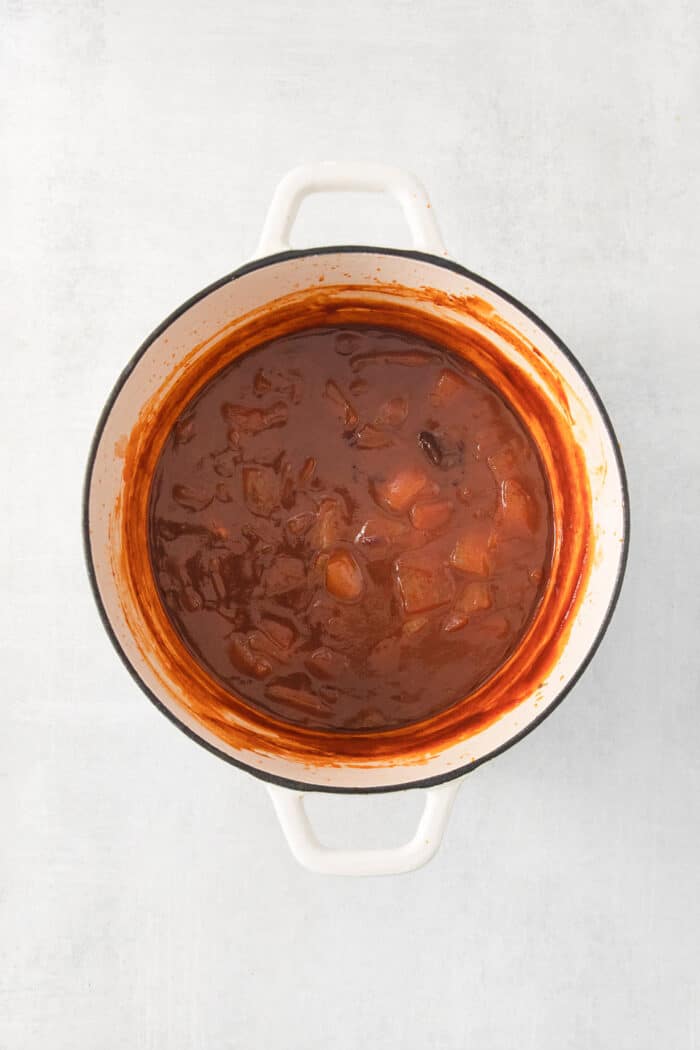 cooking the barbecue sauce in a white pot