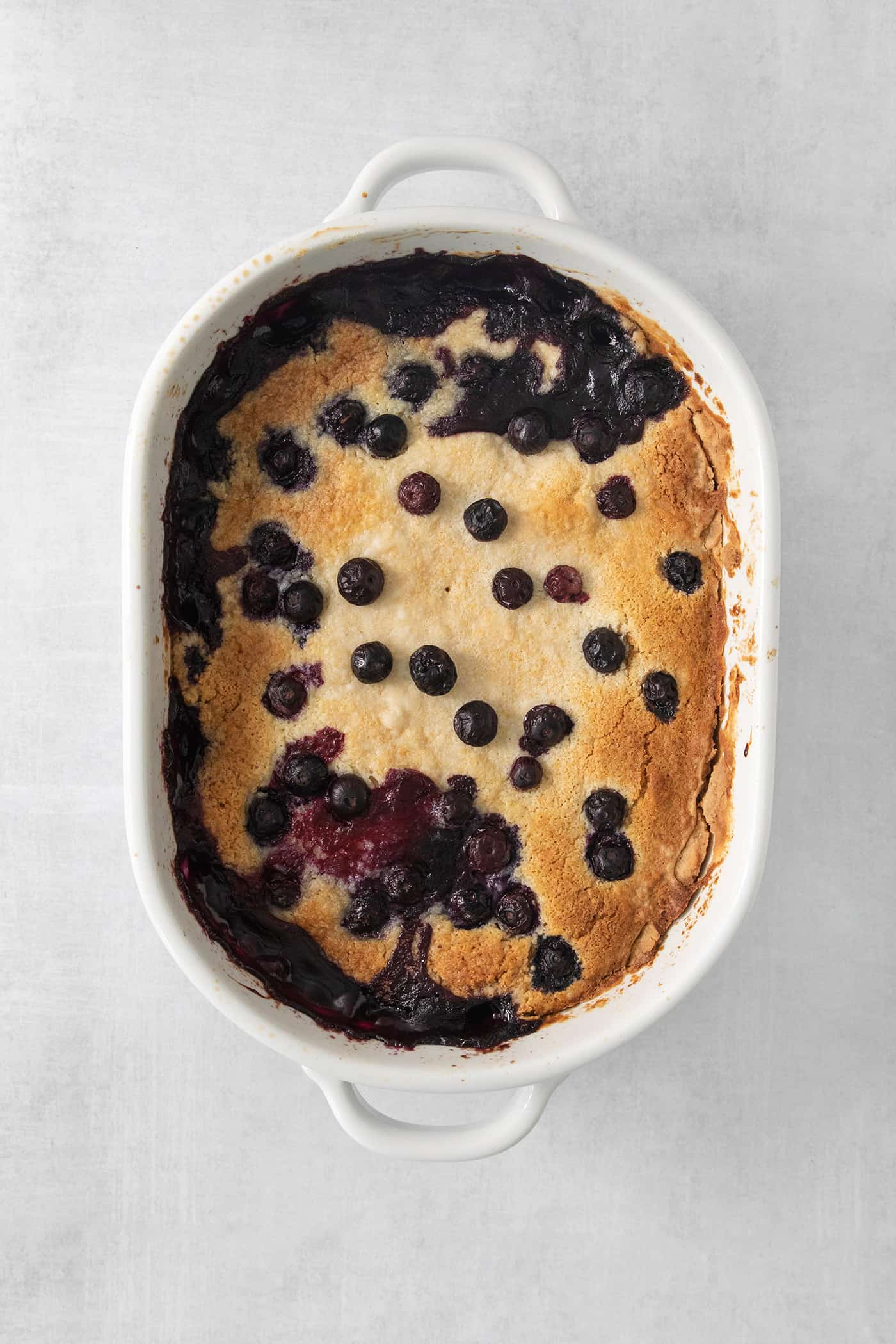 Blueberry dump cake in a white baking dish.