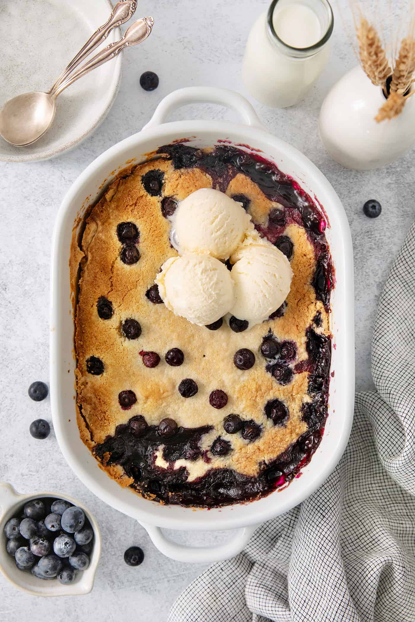 Blueberry dump cake in a pan topped with ice cream.