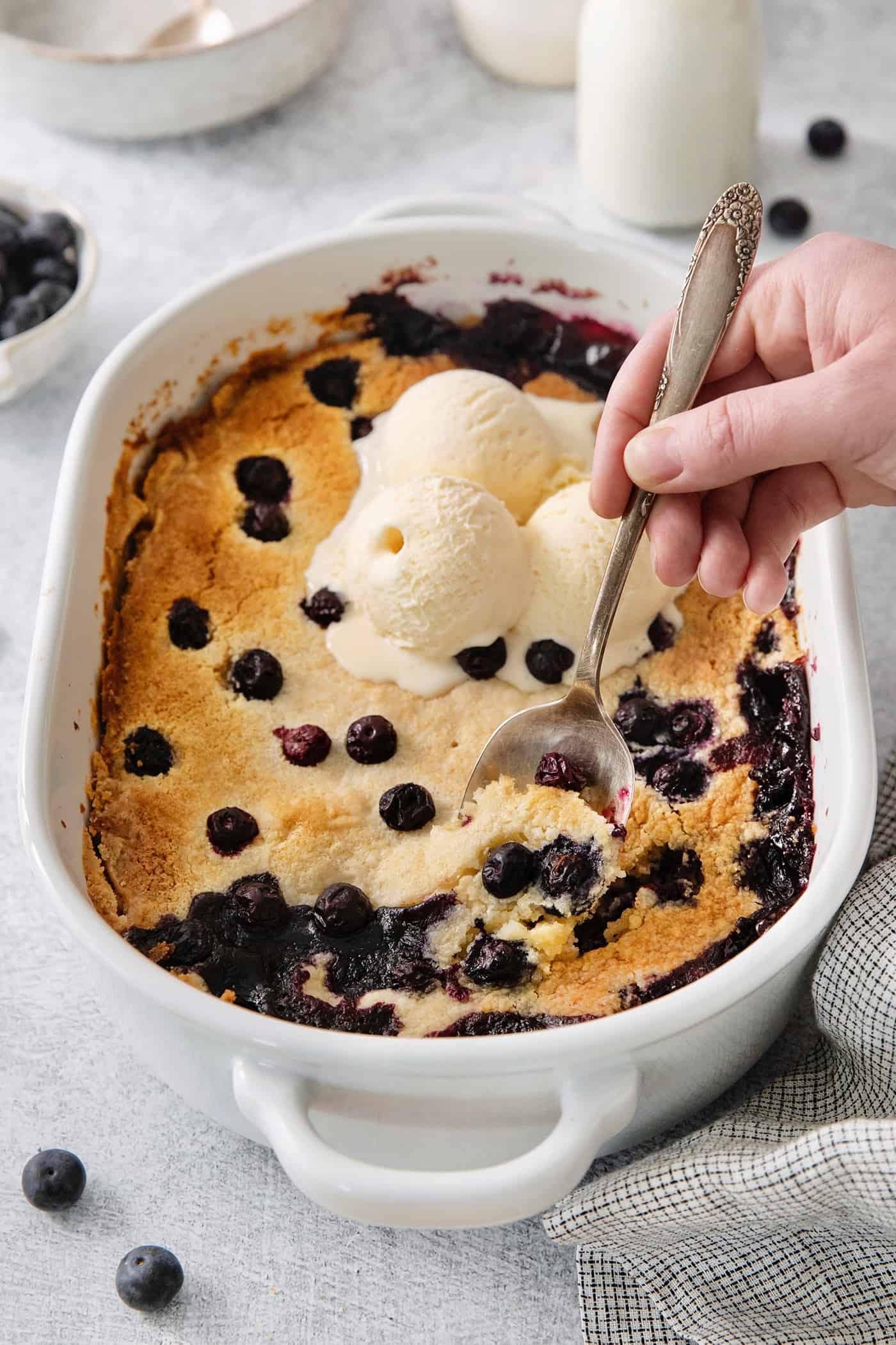 A spoon scoops out a portion of blueberry dump cake.