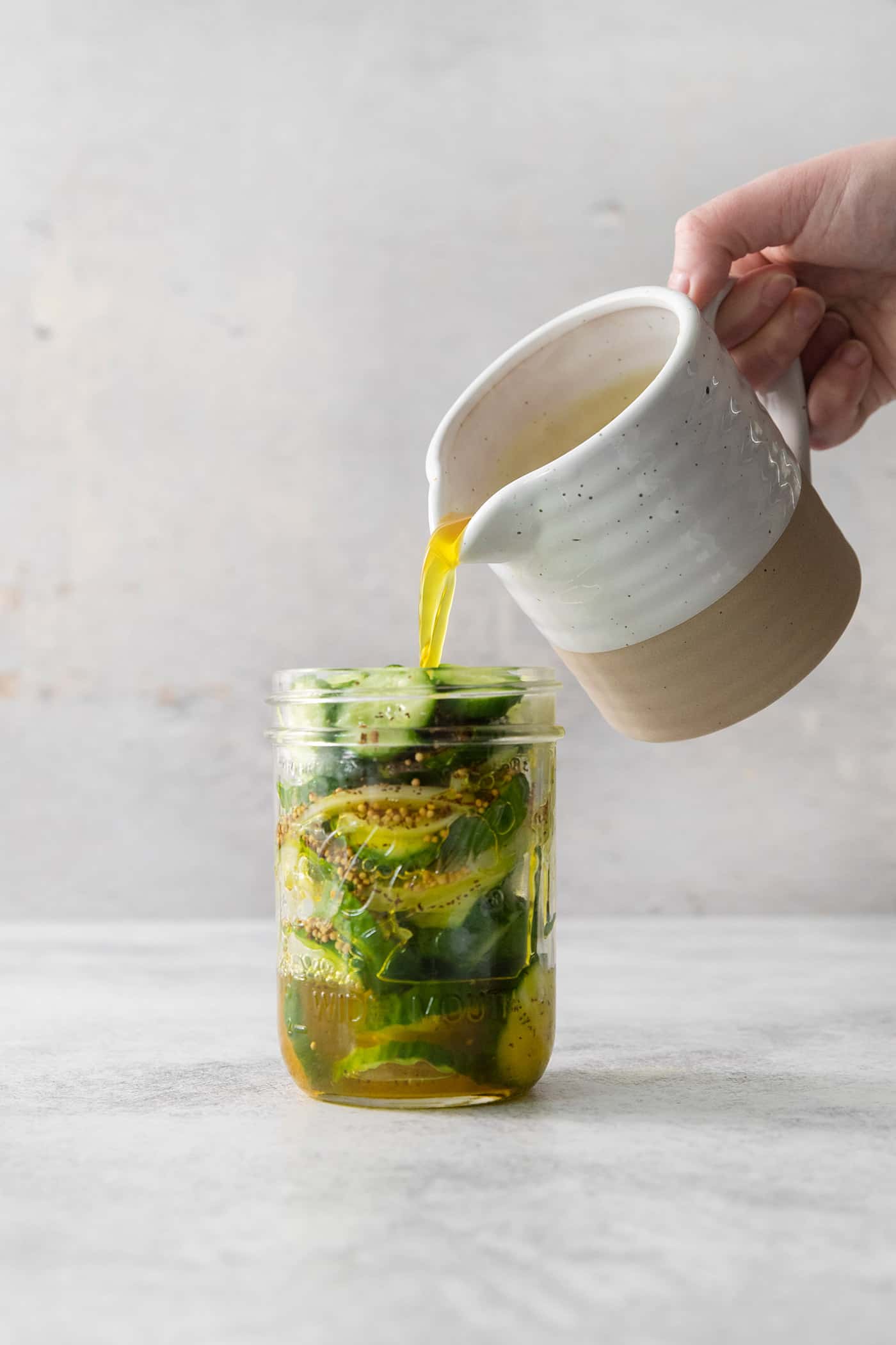 Brine is poured into a jar of pickles.