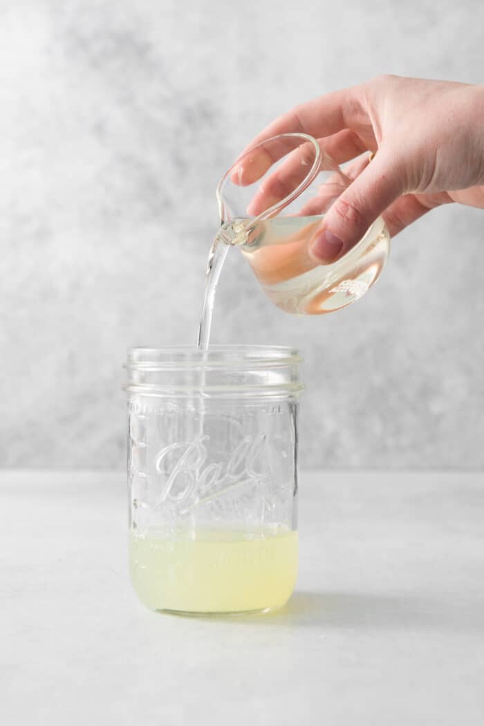 Lime juice being poured into a mason jar