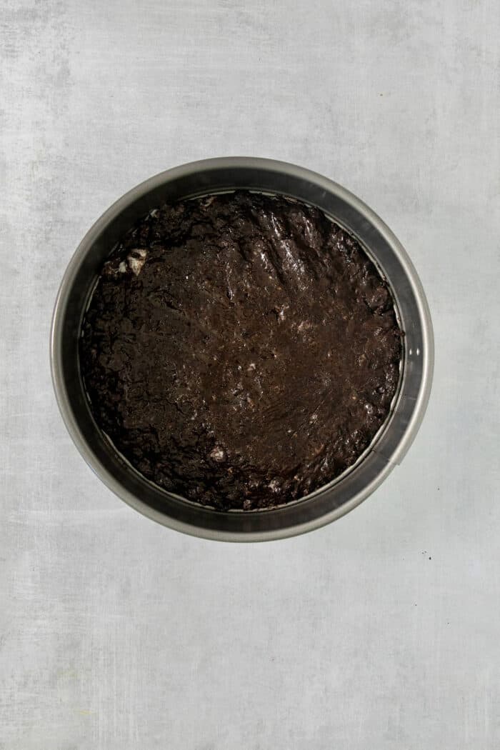 Oreo and hot fudge crust pressed into a springform pan