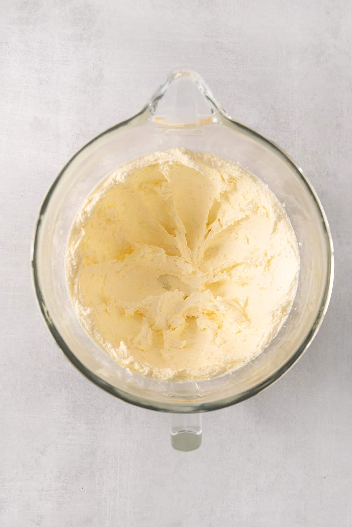 Lemon pound cake batter in a clear bowl.