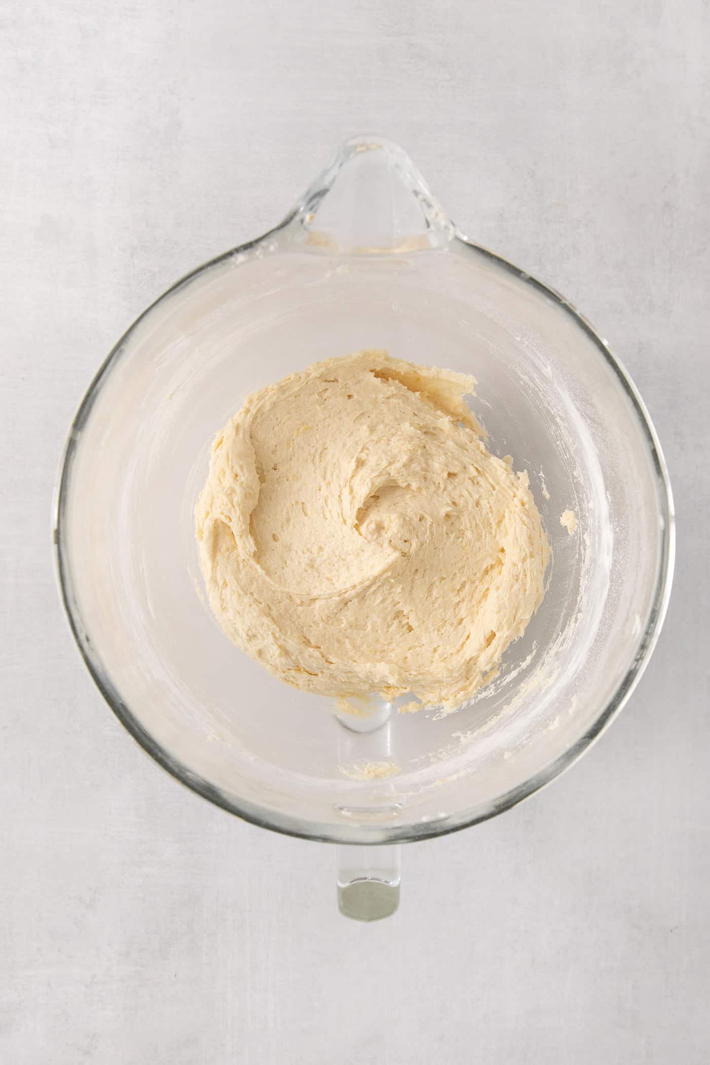 Lemon pound cake batter in a clear bowl.