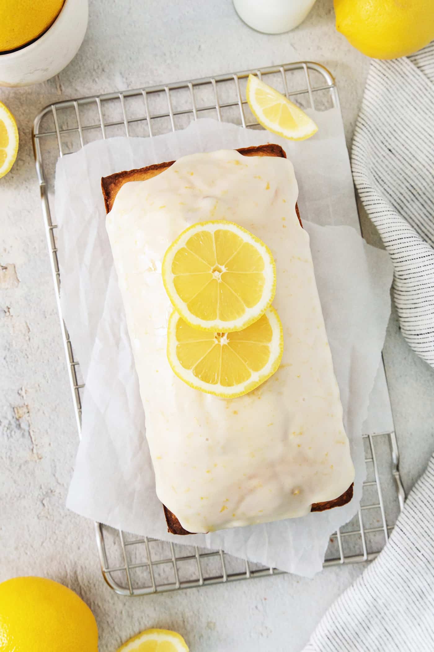 A lemon pound cake stopped with glaze and lemon slices.